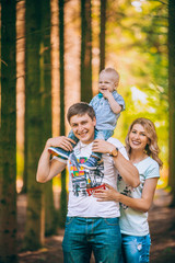 Fototapeta premium celebration, family, holidays and birthday concept - happy young family in caps in the summer in the Park