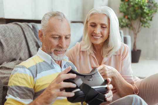 Cheerful aged couple testing VR device
