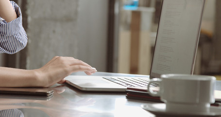 Beautiful young professional reading something on her laptop, co-working office