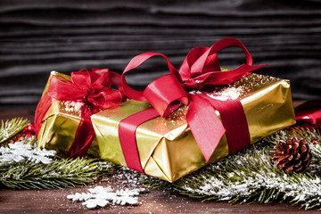 gifts boxes with fir branches on wooden background close up