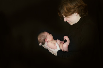 mom and newborn baby on dark background close-up © natalialeb