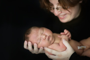 mom and newborn baby on dark background close-up © natalialeb