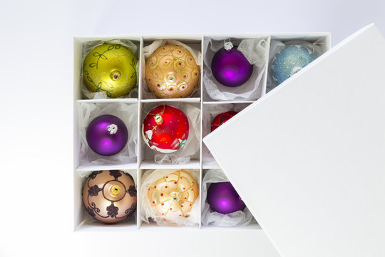 White box with colorful ornate christmas balls on white background