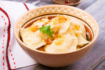 Dumplings, filled with potato and served with fried onion. Varenyky, vareniki, pierogi, pyrohy -...
