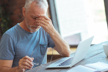 Sick aged man sitting at the table