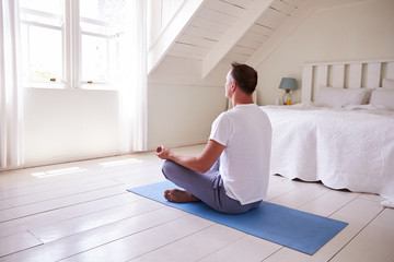 Mature Man With Digital Tablet Using Meditation App In Bedroom