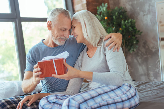 Positive loving couple holding a birthday present