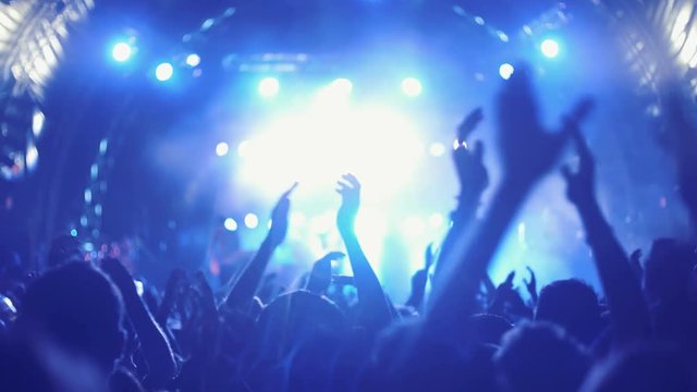 4K UHD Night rock concert front row crowd cheering hands in air.Series of real time close up shots from a night rock concert.People clap their hands in unison against the strobing stage lights.