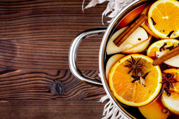 preparation of mulled wine in pot wooden background top view