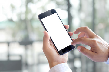 Man hands holding blank screen smartphone with blurred background.