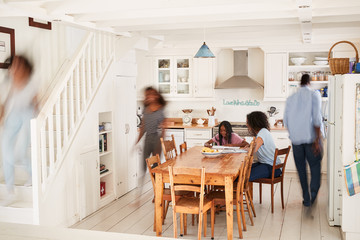Fototapeta na wymiar Interior Of Busy Family Home With Blurred Figures