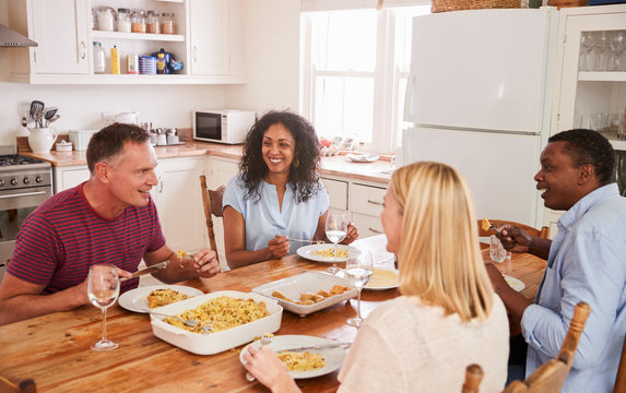 Mature Couple Entertaining Friends At Dinner Party