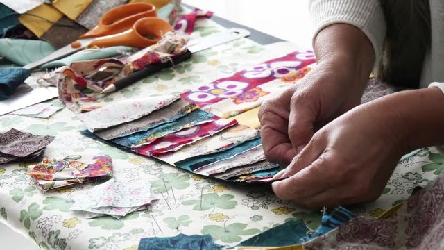 Close up of woman's hand sewing patchwork