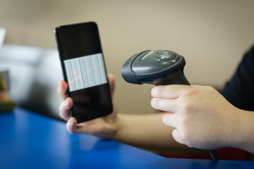 A barcode scanner scanning a barcode on a mobile/cellular phone screen. business and technology concepts.A barcode scanner scanning a barcode on a mobile/cellular phone screen. business and technology