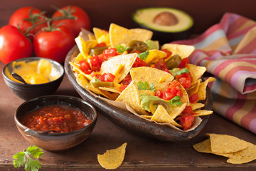 nachos loaded with salsa, guacamole, cheese and jalapeno