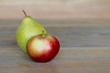 Closeup apple and pear / Red apple and green pear on wooden table