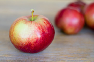 Red apple on wooden table / Ripe read apple and so more apples on background