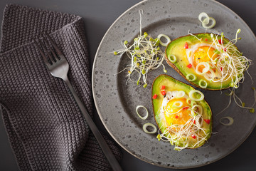 egg baked in avocado with spring onion and alfalfa sprouts