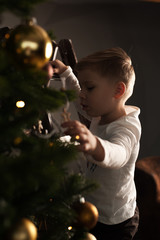 Cute caucasian child decorating Christmas tree