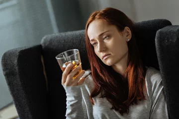 Zelfklevend Fotobehang Pleasant sad woman drinking alcohol © Viacheslav Yakobchuk