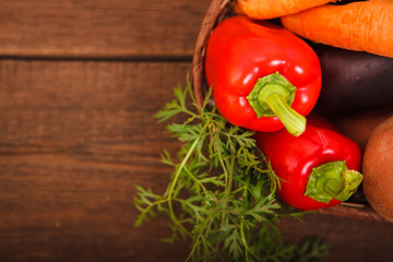 Fresh vegetables in a basket on a wooden background. Harvest. Thanksgiving Day. Space for text. Background.