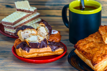 eclairs on a red plate on a wooden background