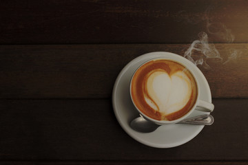 Hot coffee latte art on wooden background