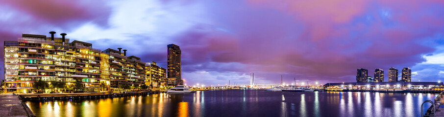 Fototapeta premium Panorama view of a beautiful view of docklands and The Bolte Bridge with a cloudy sky and twilight in Melbourne Australia.