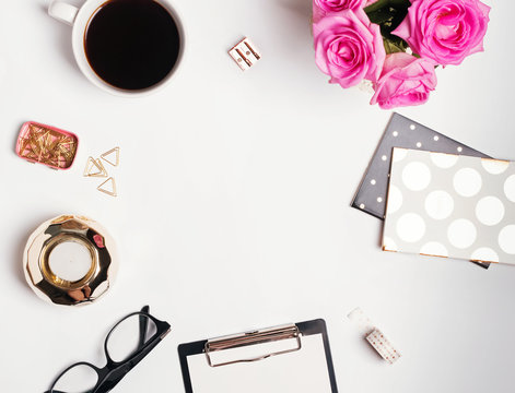Feminine workplace concept: cofee, roses and small gold color accessories