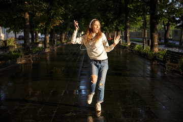 Full length image of joyful brunette woman in autumn clothes