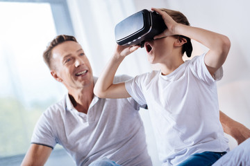 Excited little boy playing with VR headset
