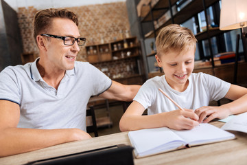 Pre-teen boy doing homework with father in the study