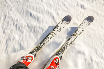 Close up of boots and ski in the motion during speed downhill. Extreme sport