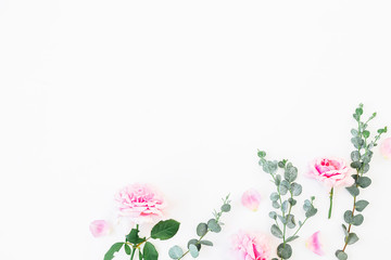 Flower composition of pink petals and eucalyptus on white background. Flat lay, top view. Valentine's background.