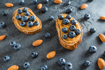 Snack with bread, peanut butter and blueberries. Healthy food concept.