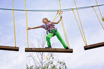 Teenage girl is walking on a board in an extreme park