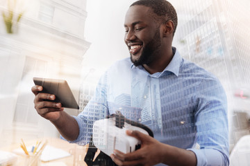 Smiling African American holding device in the hand