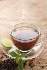 Hot tea of cup with slice of lemon on hemp sack for break fast and drinking time in morning