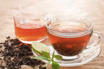 Hot tea of cup with slice of lemon on hemp sack for break fast and drinking time in morning