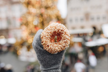 Sweet donut in hand on blur background