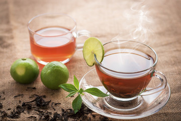 Hot tea of cup with slice of lemon on hemp sack for break fast and drinking time in morning