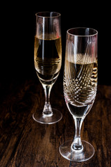 Champagne glasses on dark wooden surface.