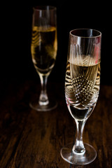 Champagne glasses on dark wooden surface.