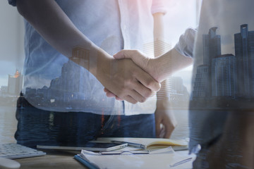 double exposure businessman shaking hand and city, concept as team work and cooperation in success business