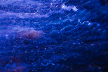 Abstract background of lines in motion on black. Bokeh of defocused curves, blurred neon white and blue leds, similar to stellar system, nebulosity and the Galaxy, comet and stars backdrop