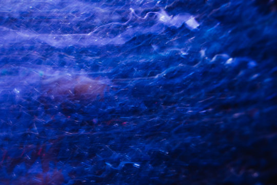 Abstract background of lines in motion on black. Bokeh of defocused curves, blurred neon white and blue leds, similar to stellar system, nebulosity and the Galaxy, comet and stars backdrop