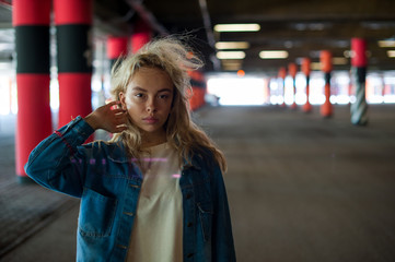 young beautiful woman in jeans clothes in parking of shopping center. portrait of a girl with freckles on her face