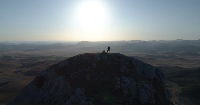 man stands on top of a mountain