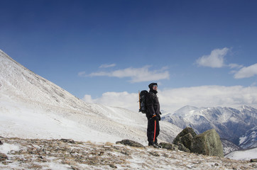 Fototapeta premium Hiker stays on a snow mountain hill and enjoy beautiful view.