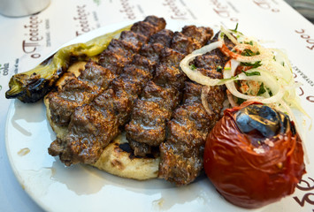 Kebab of pork with vegetables on pita.